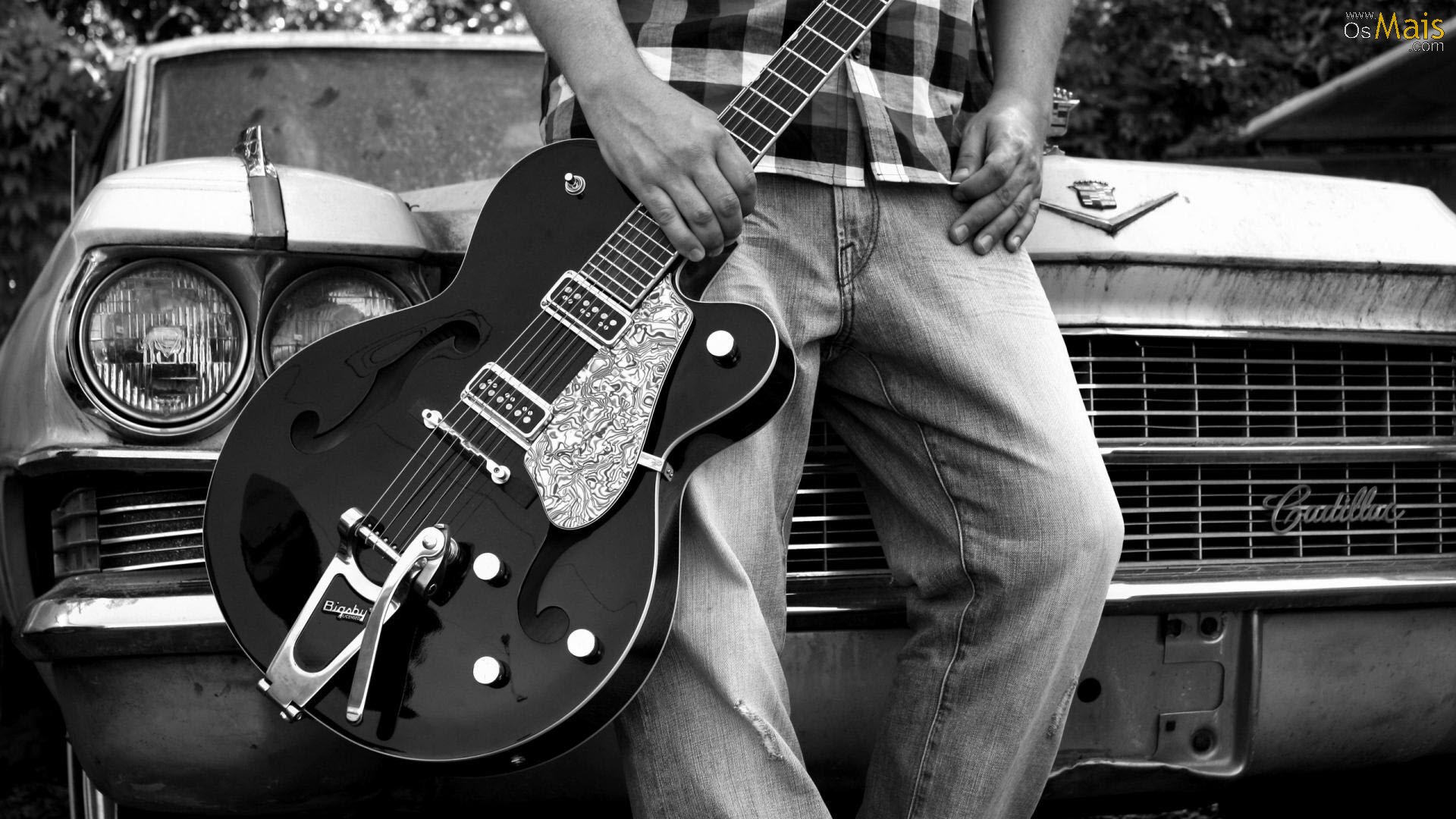 Guitarrista posando em frente a um cadillac